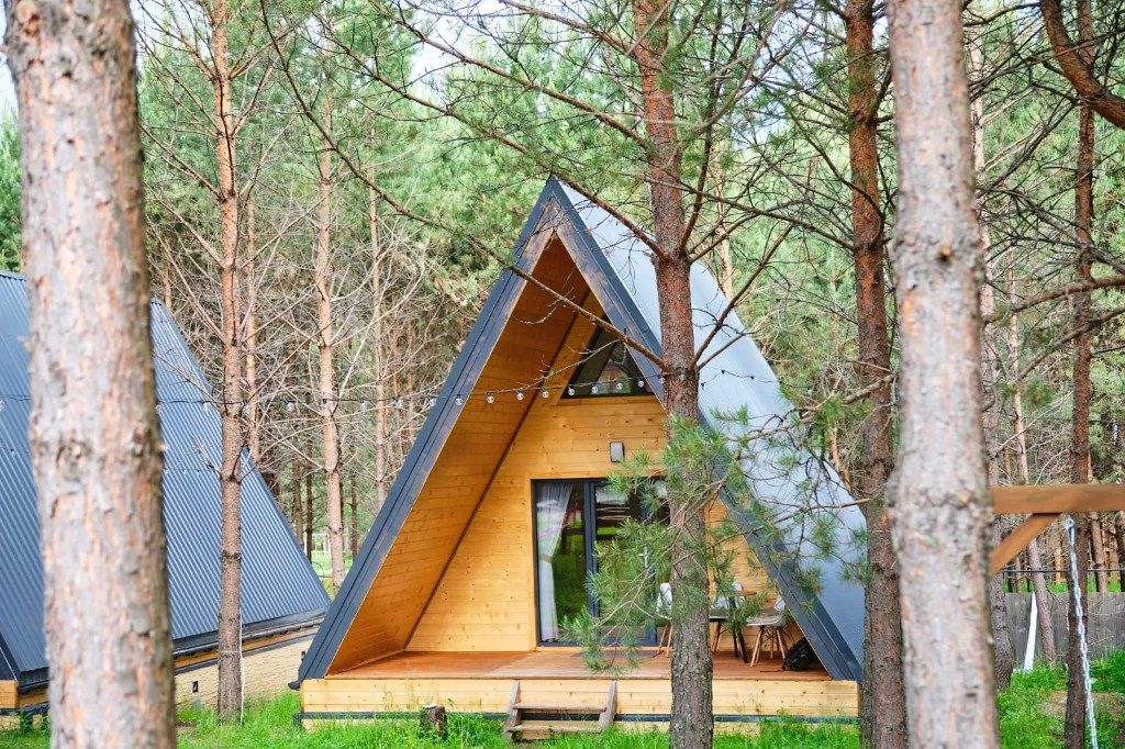 А-фрейм Pine Paradise среди сосен, светлая веранда и серая кровля